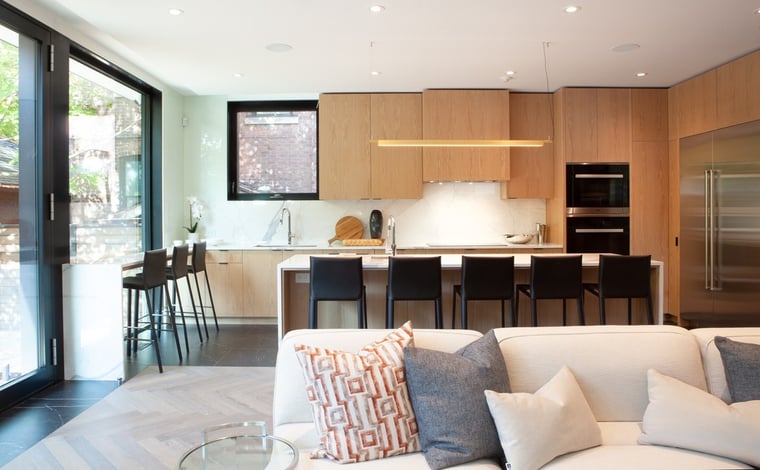 Open-concept living room and kitchen view with expansive windows and hard wood flooring