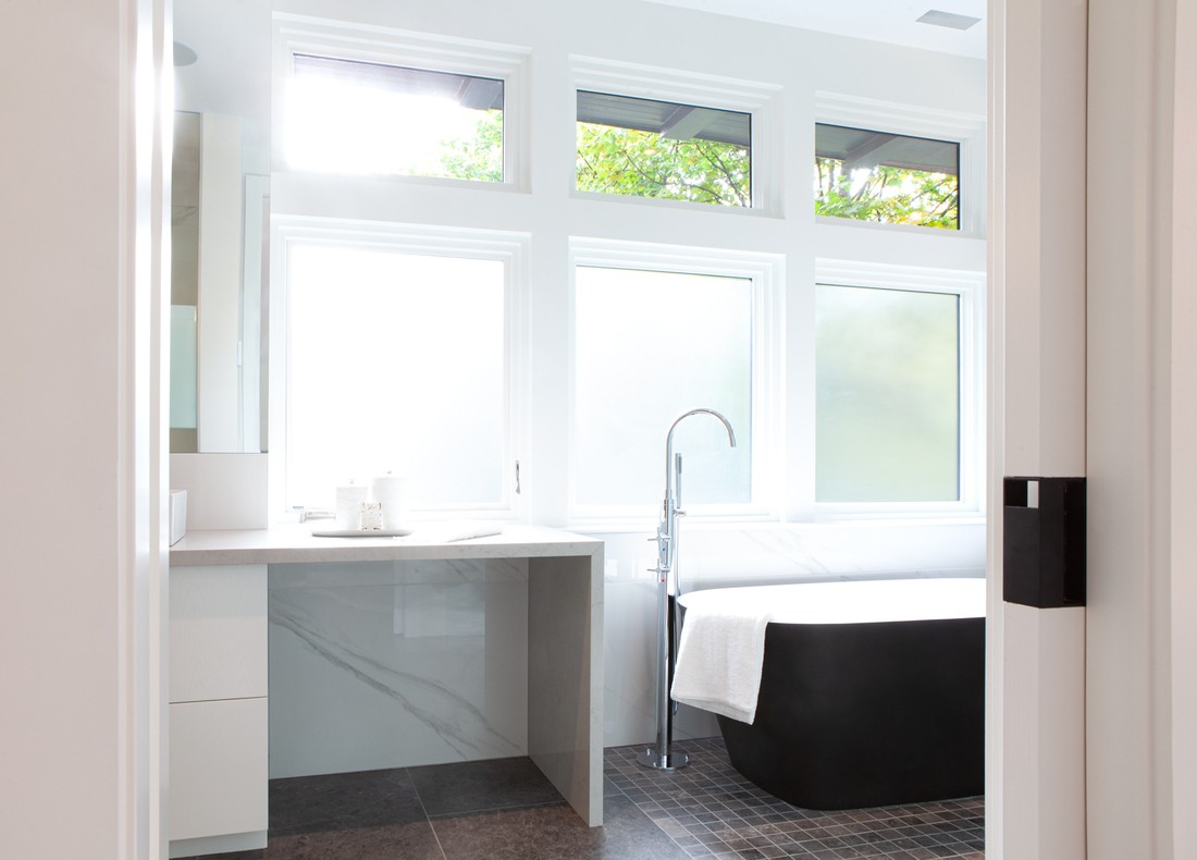 Primary bathroom with film windows and freestanding tub