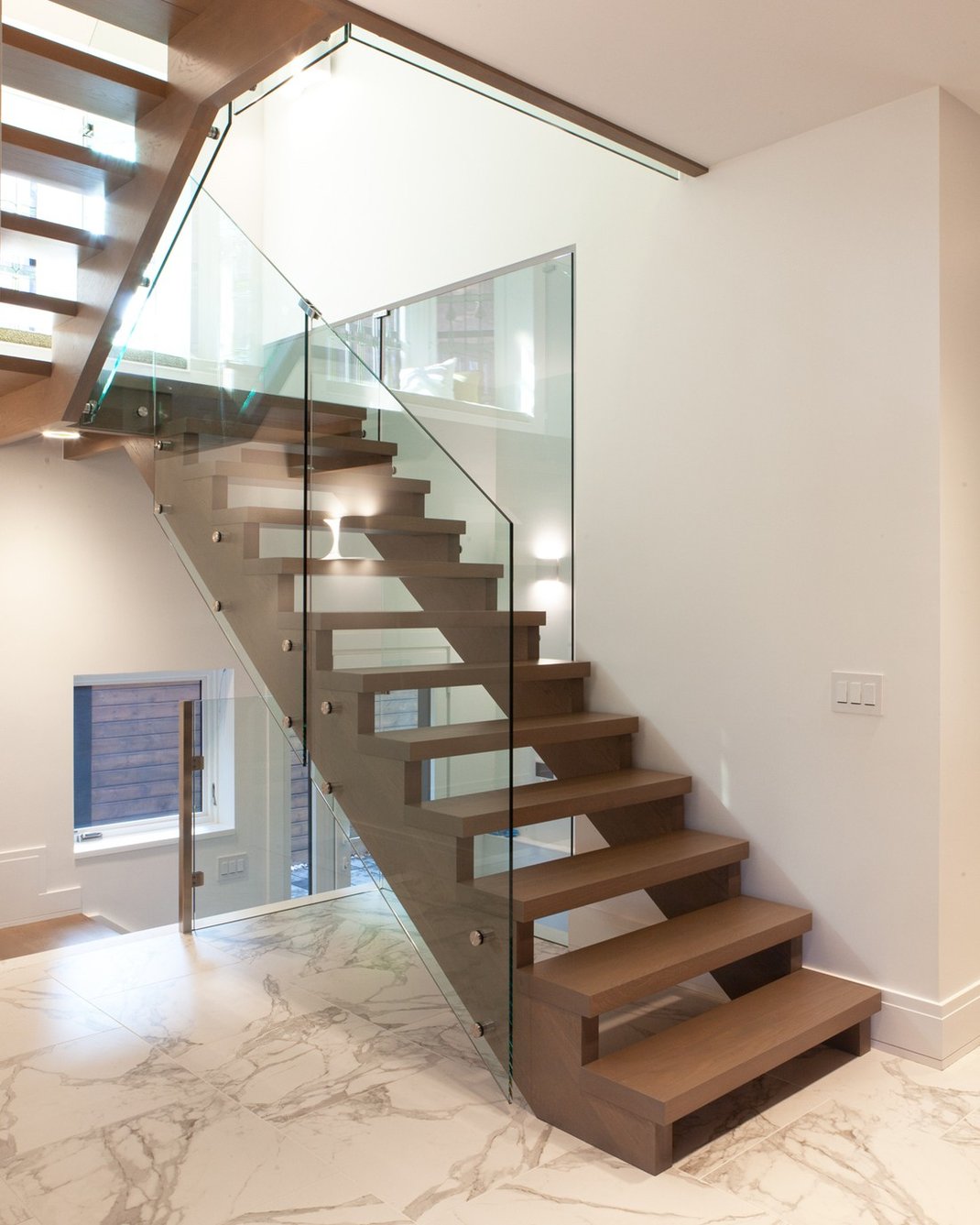Staircase in luxury Toronto custom home with glass panel installations