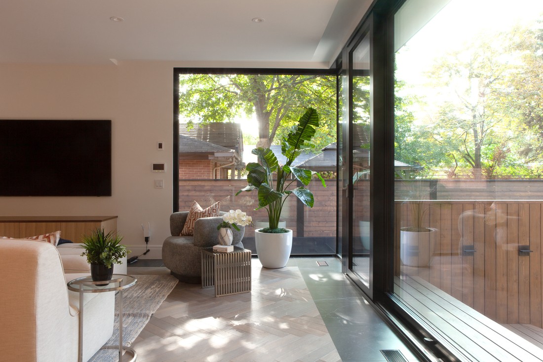 View of living room in Rosedale, Toronto custom home with floor-to-ceiling windows and indoor plants