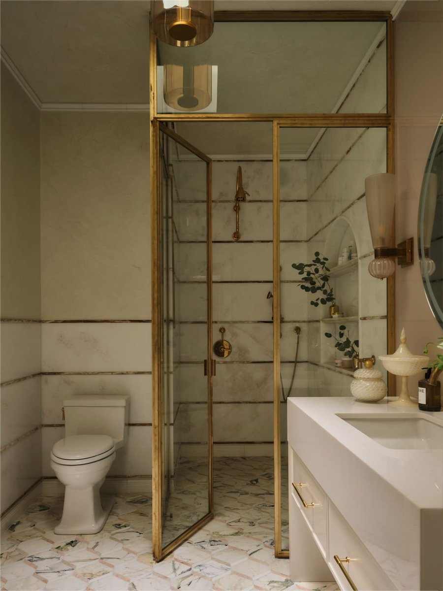 Bathroom with marble tile, glass shower enclosure, and modern white vanity, located in Toronto