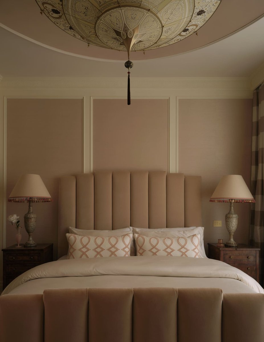 Bedroom view with upholstered bed and ornate ceiling light, featuring warm neutral tones, located in Toronto