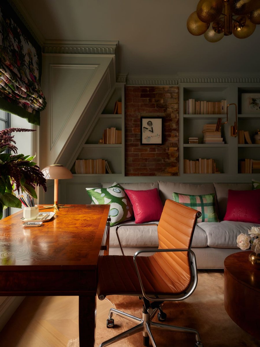 Cozy home office with built-in shelves, brick accent wall, wooden desk, and modern lighting in Toronto