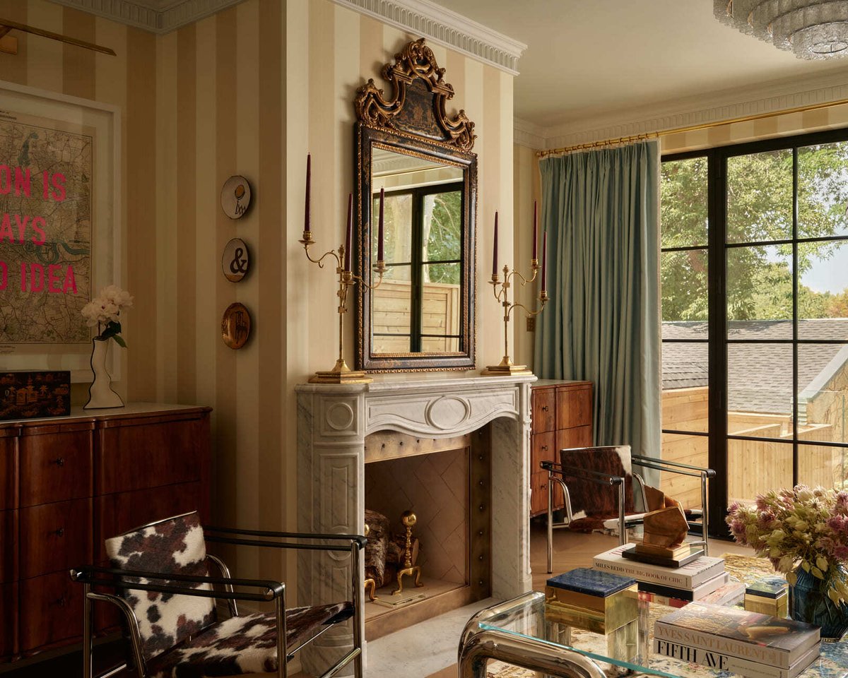 Sophisticated Toronto living room with marble fireplace, ornate mirror, striped walls, leather chairs, and glass coffee table
