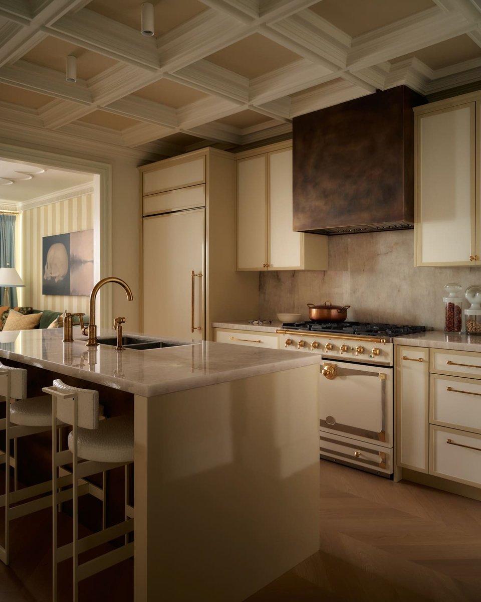 Toronto kitchen view with marble countertops, brass fixtures, custom cabinetry, coffered ceiling, and warm, elegant finishes