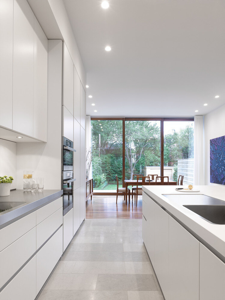 Gray and white countertops in Toronto custom kitchen with floor-to-ceiling windows in back
