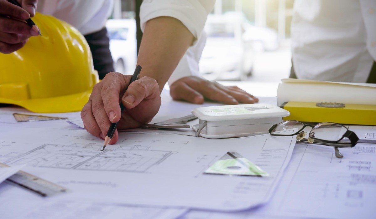 Residential Architect Drawing Out Plans of Home on Table