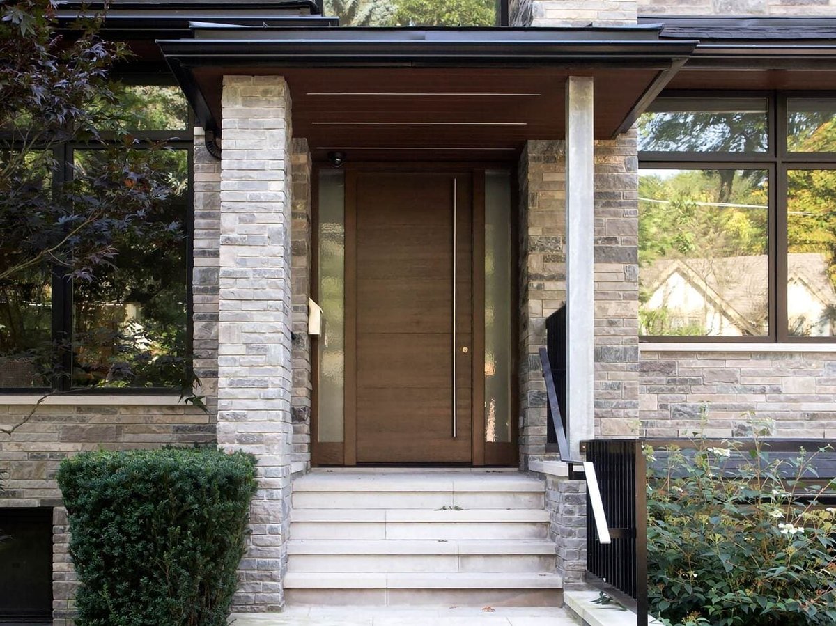 Brown modern front door with stone exterior siding and windows by SevernWoods  