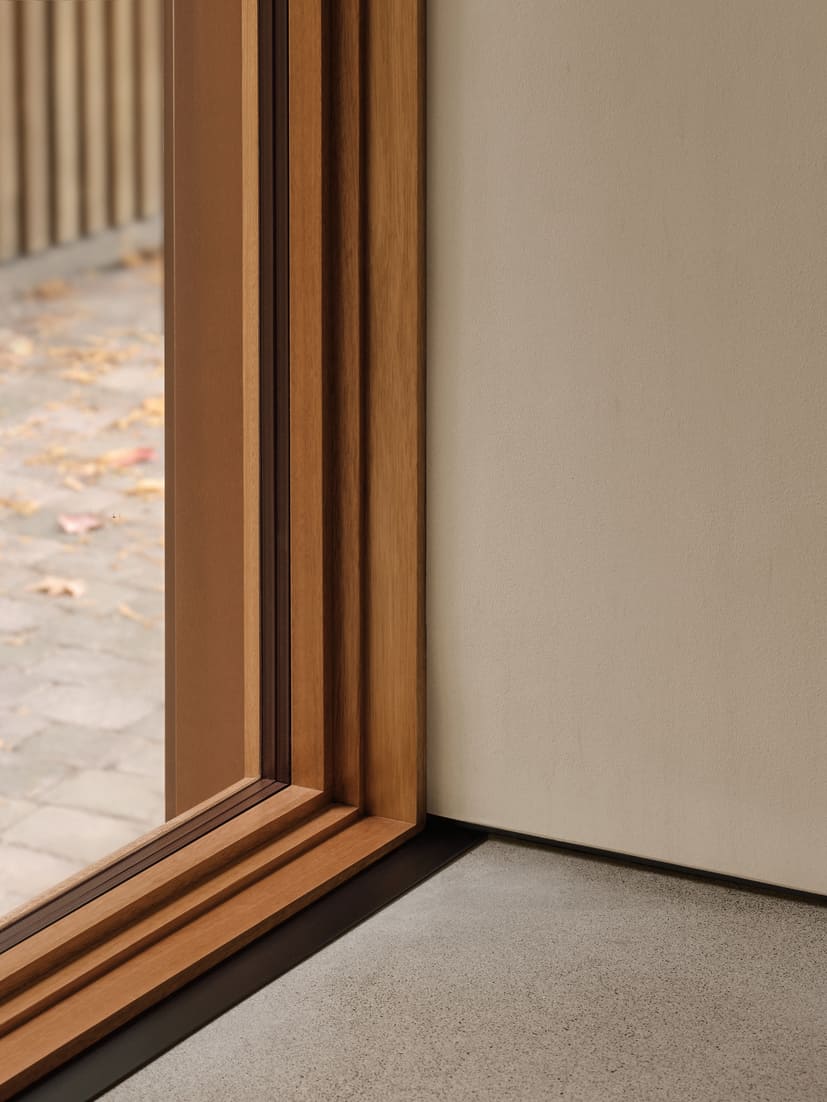 Toronto architectural detail of wood-framed window corner and clean wall junction with polished concrete floor