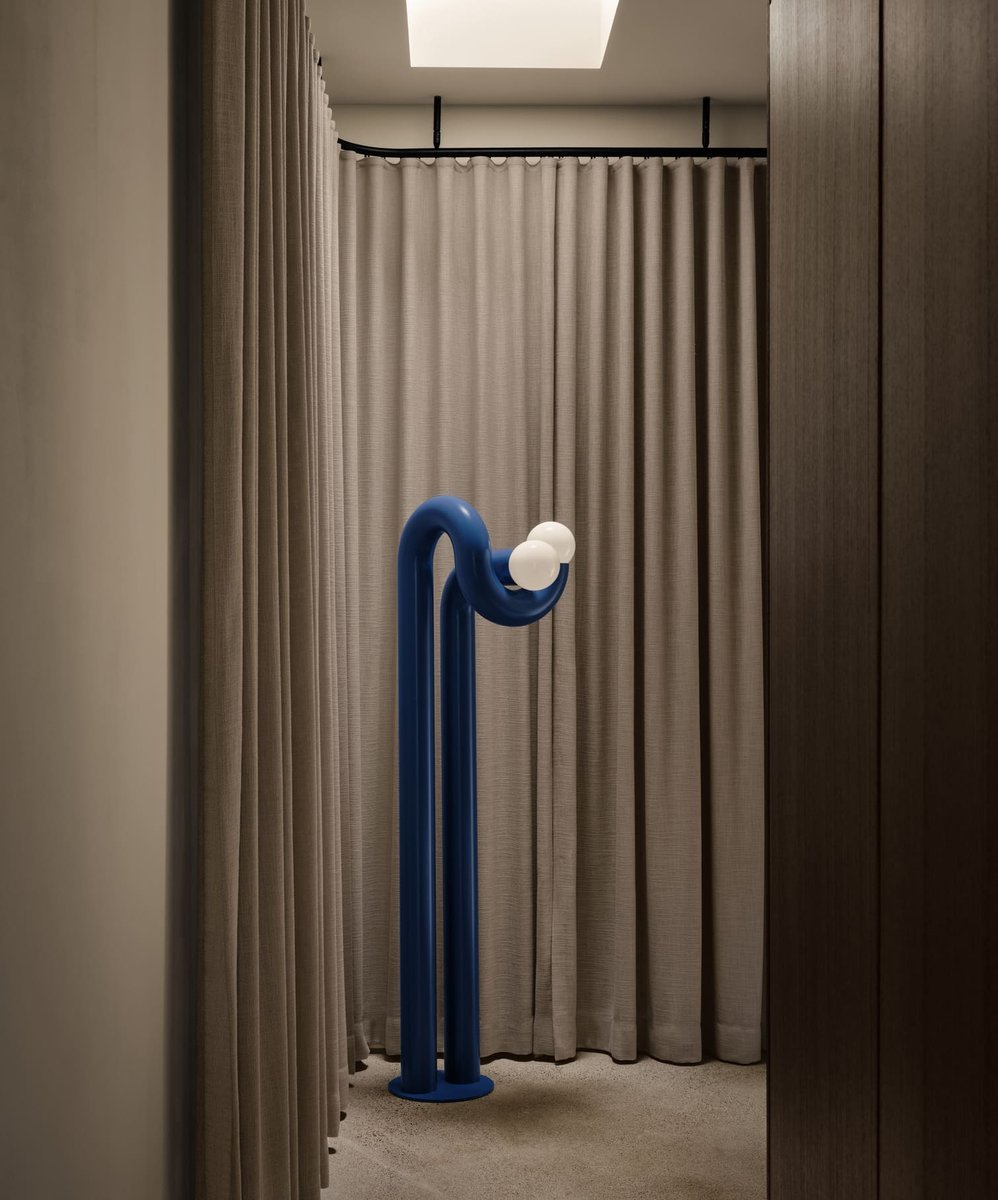 Toronto modern interior with sculptural blue floor lamp, soft beige curtains, and minimalist lighting in a cozy, enclosed space