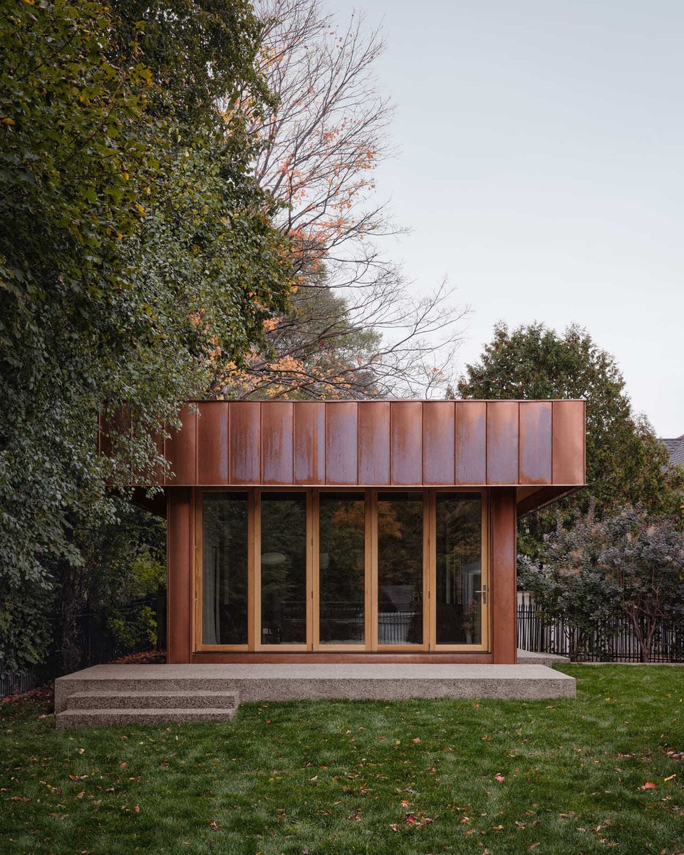 Toronto modern rear facade with weathered copper panels, glass doors, and greenery highlighting clean lines and outdoor connection