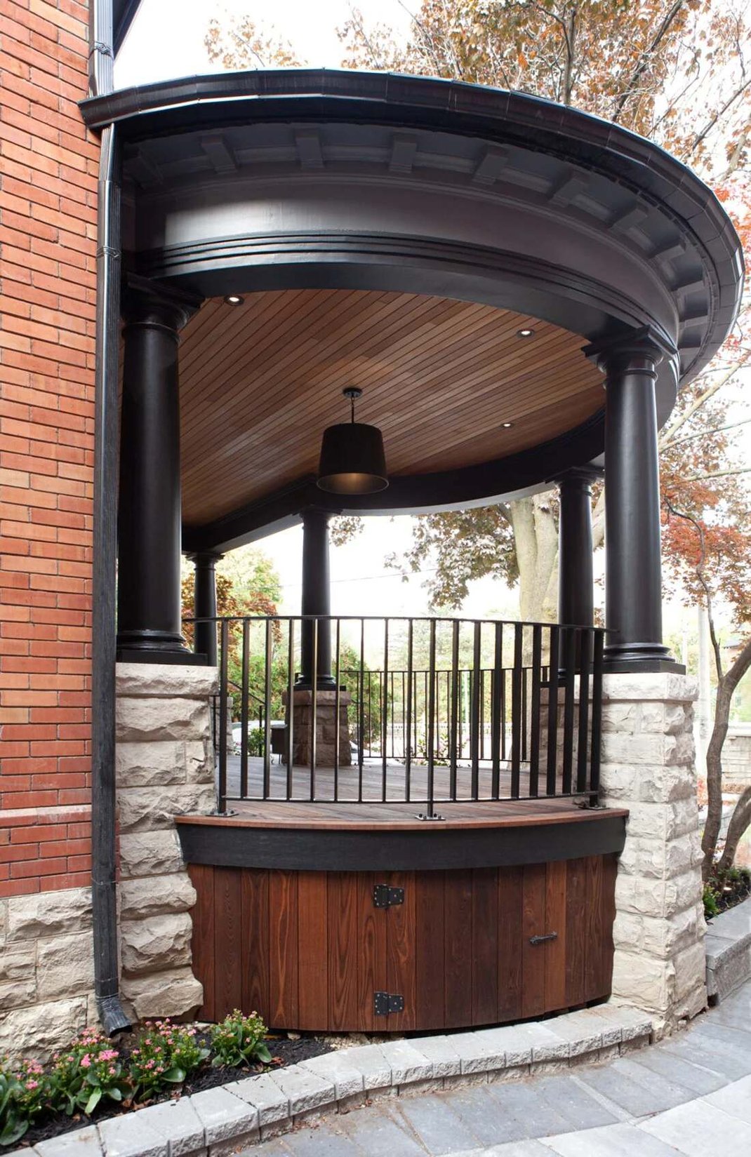 Custom home round front porch exterior with black and stacked stone posts