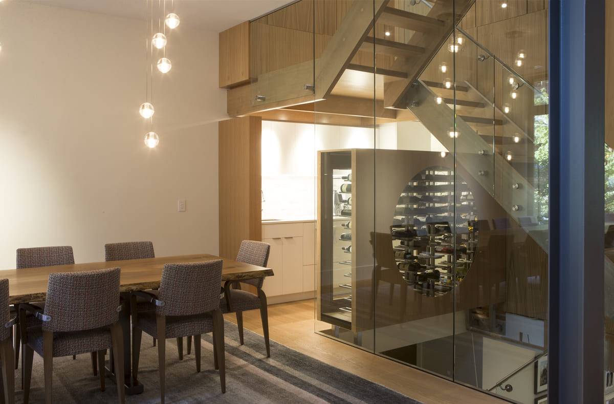 Dining room and wine storage with glass panelling by in Toronto custom home by SevernWoods