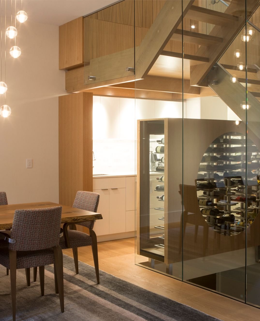 Dining room with floating glass staircase in custom luxury home in Toronto