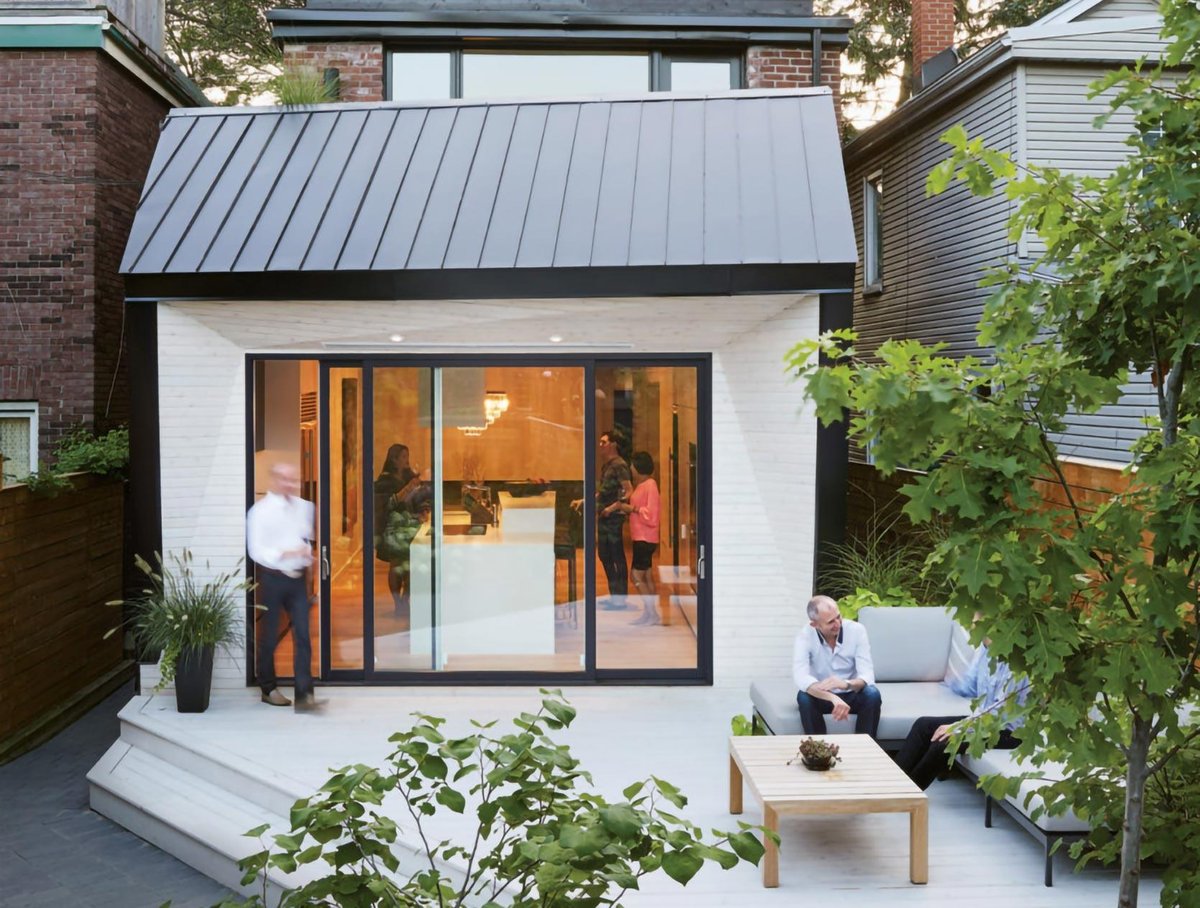 Exterior of Toronto modern home addition by SevernWoods with people on couch