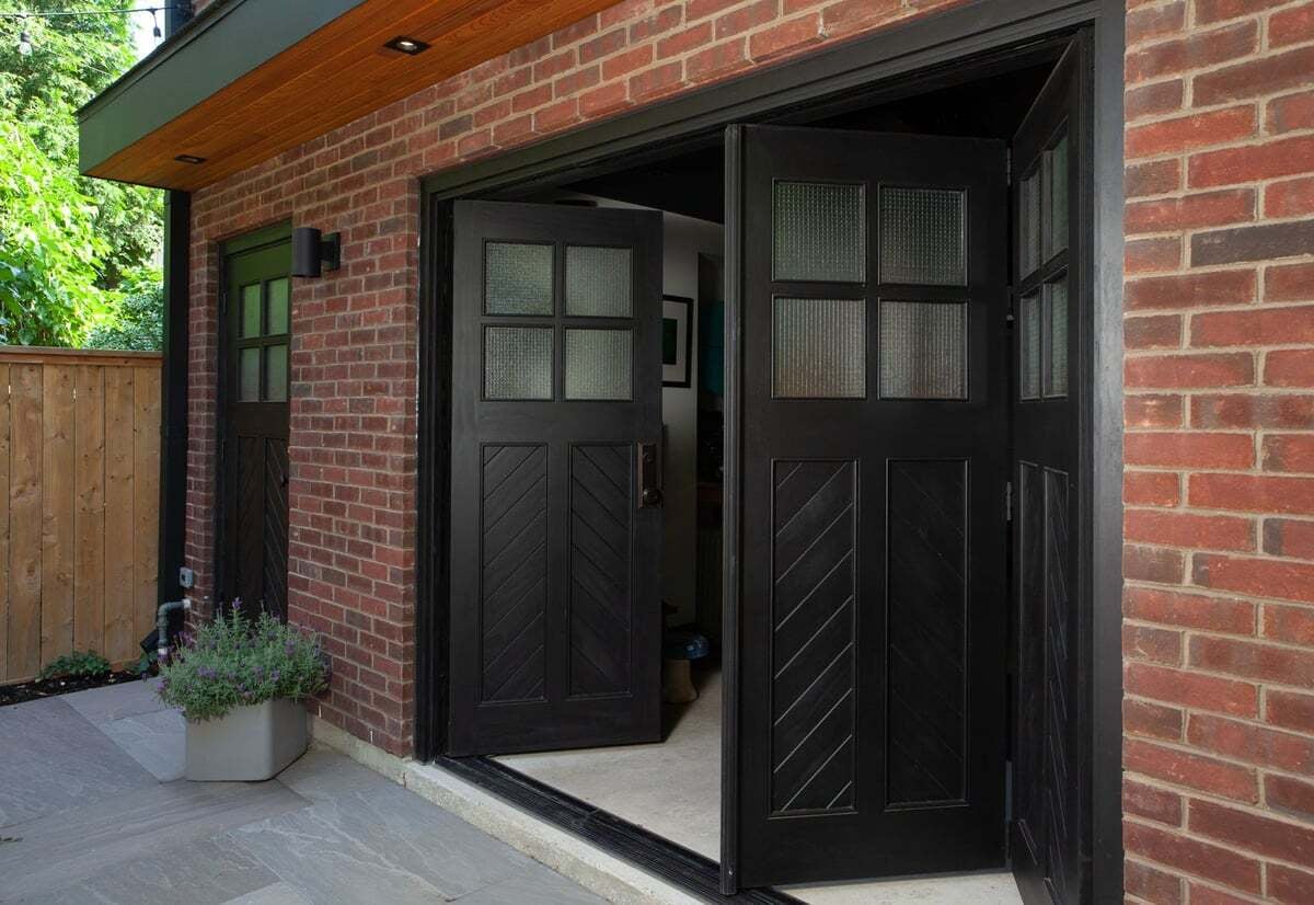 black-bi-fold-doors-open-brick-facade-laneway-danforth-severnwoods-toronto