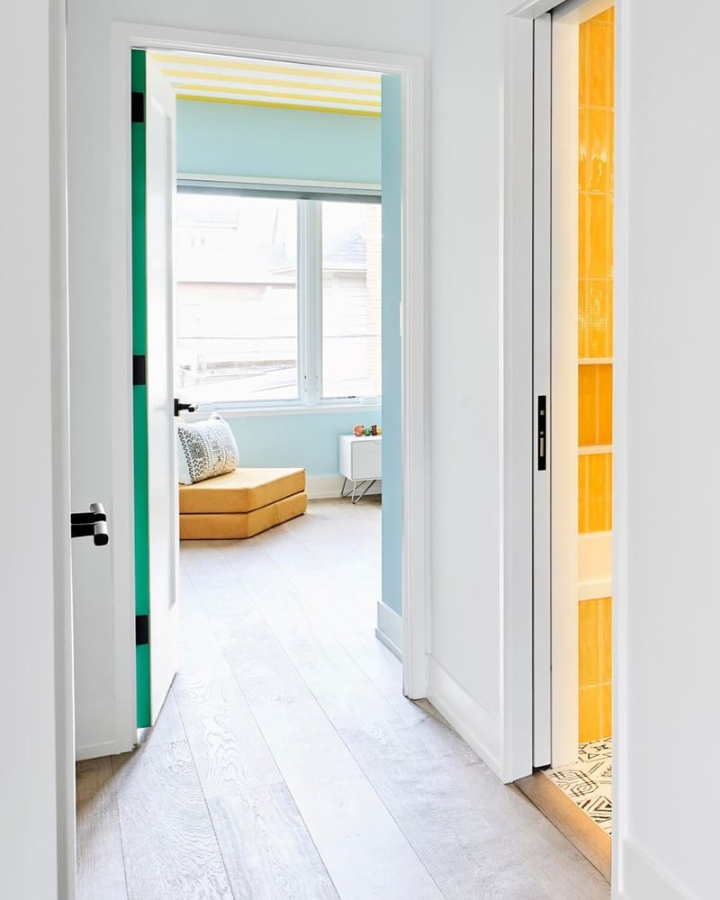 Hallway door opening to kids' bedroom with hardwood flooring and windows