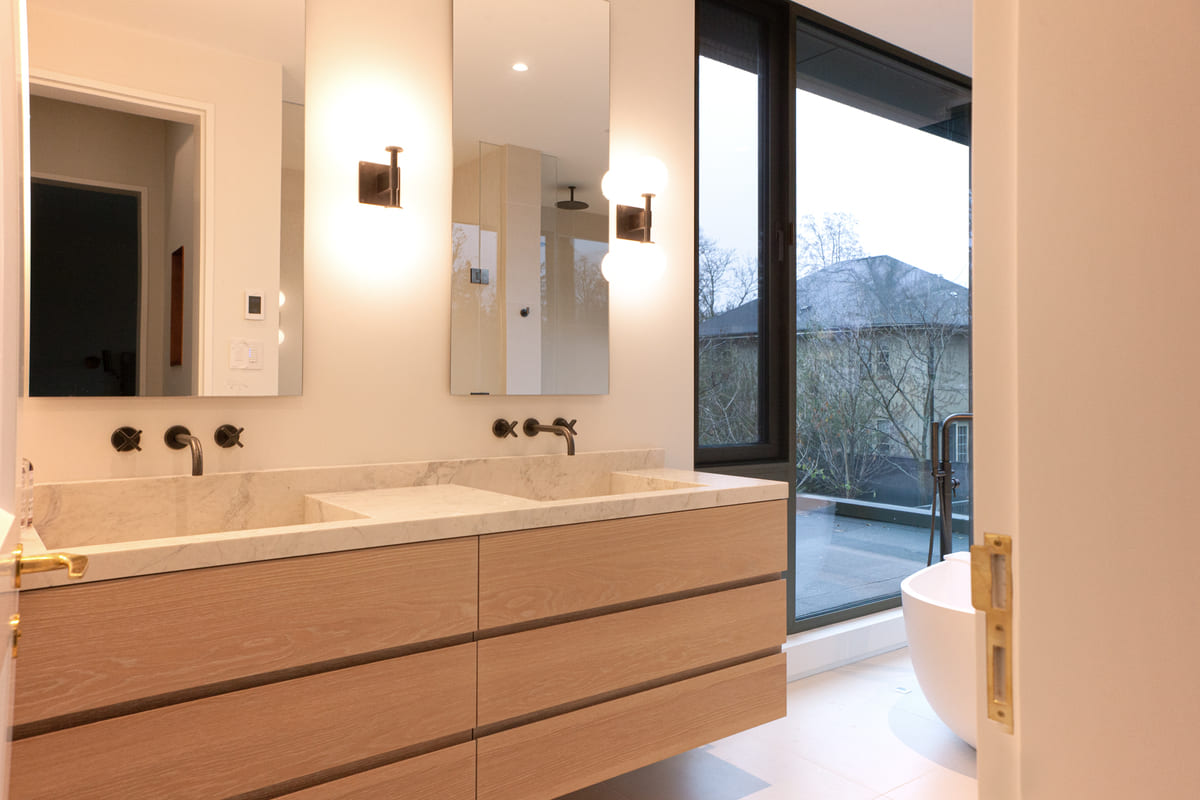 Luxury custom bathroom with double floating vanity and freestanding tub by floor-to-ceiling window