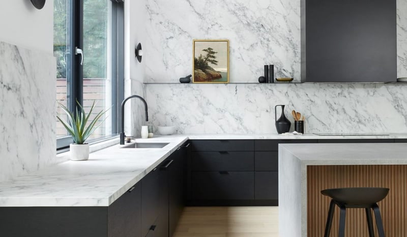 Luxury kitchen with marble slab backsplash and countertop above black cabinets