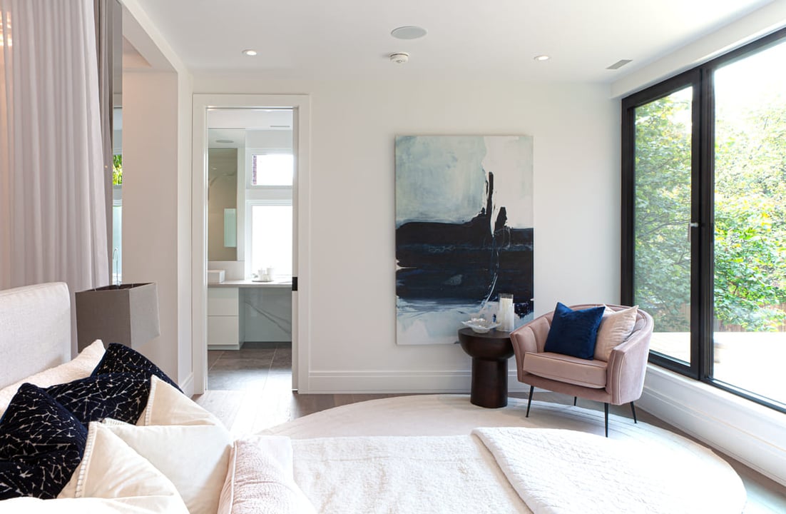 Luxury main bedroom in Toronto home renovation with ensuite bathroom through door