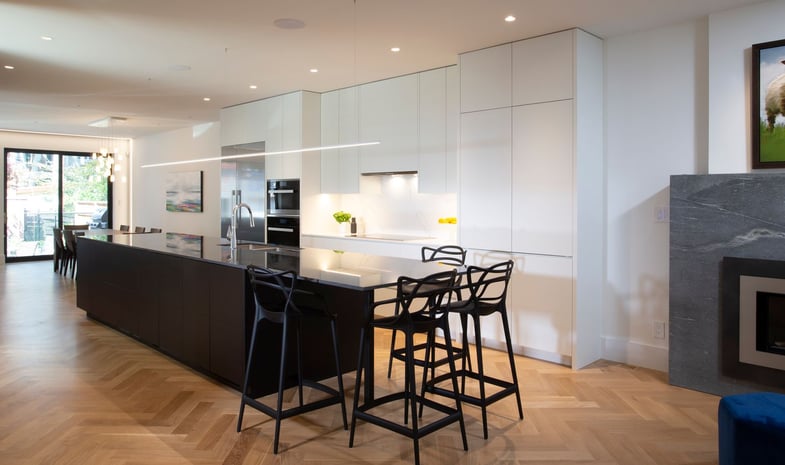 Flush White Flat Panel Cabinetry in Renovated Kitchen With Extended Island for Seating