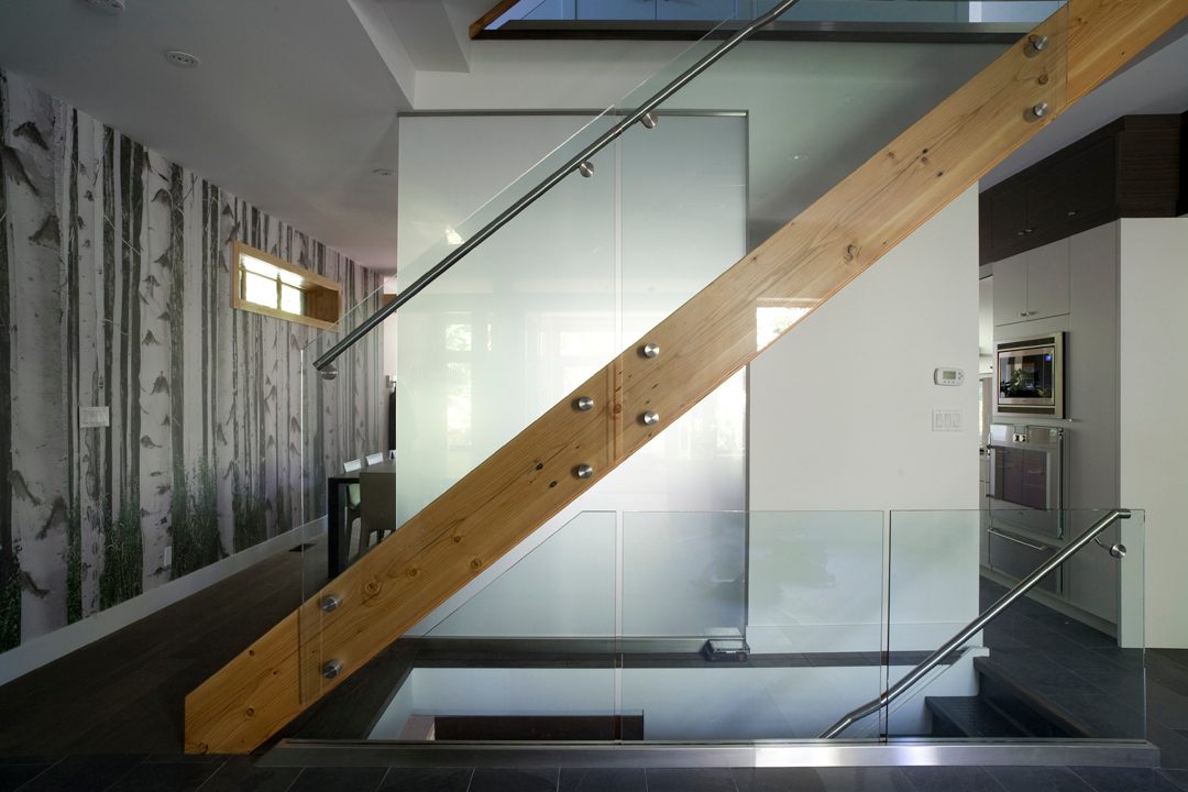 Staircase in Home With Flat Glass Railing and Wood Stairs