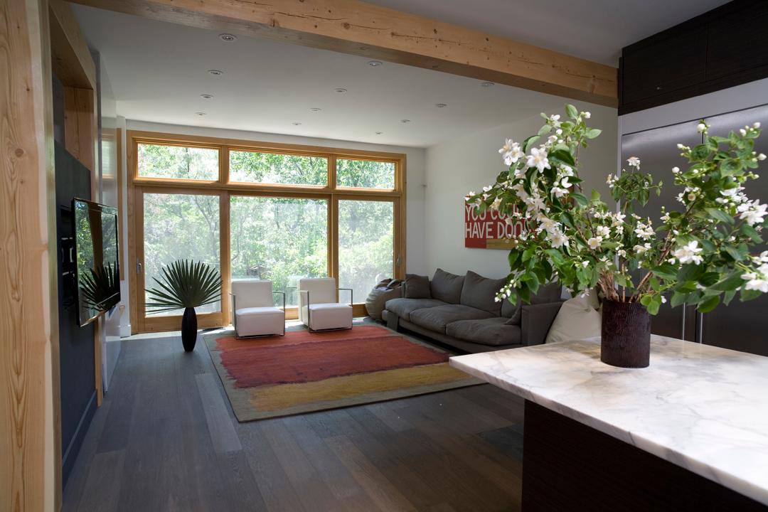 Living Room Area With Wood-Framed Floor-to-Ceiling Windows and Plant Decor