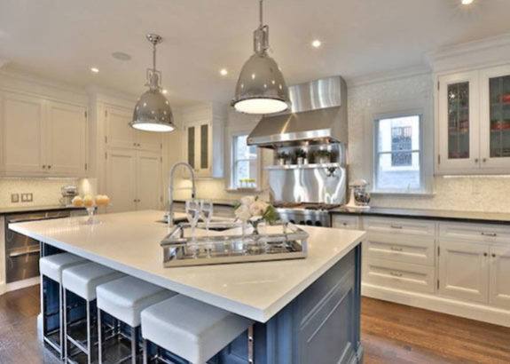 Toronto kitchen with large island, white cabinetry, pendant lighting, stainless appliances, and seating in a bright, modern open layout