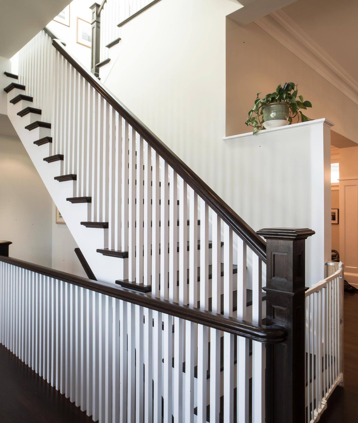 Staircase with white railing and wood newell posts by SevernWoods of Toronto