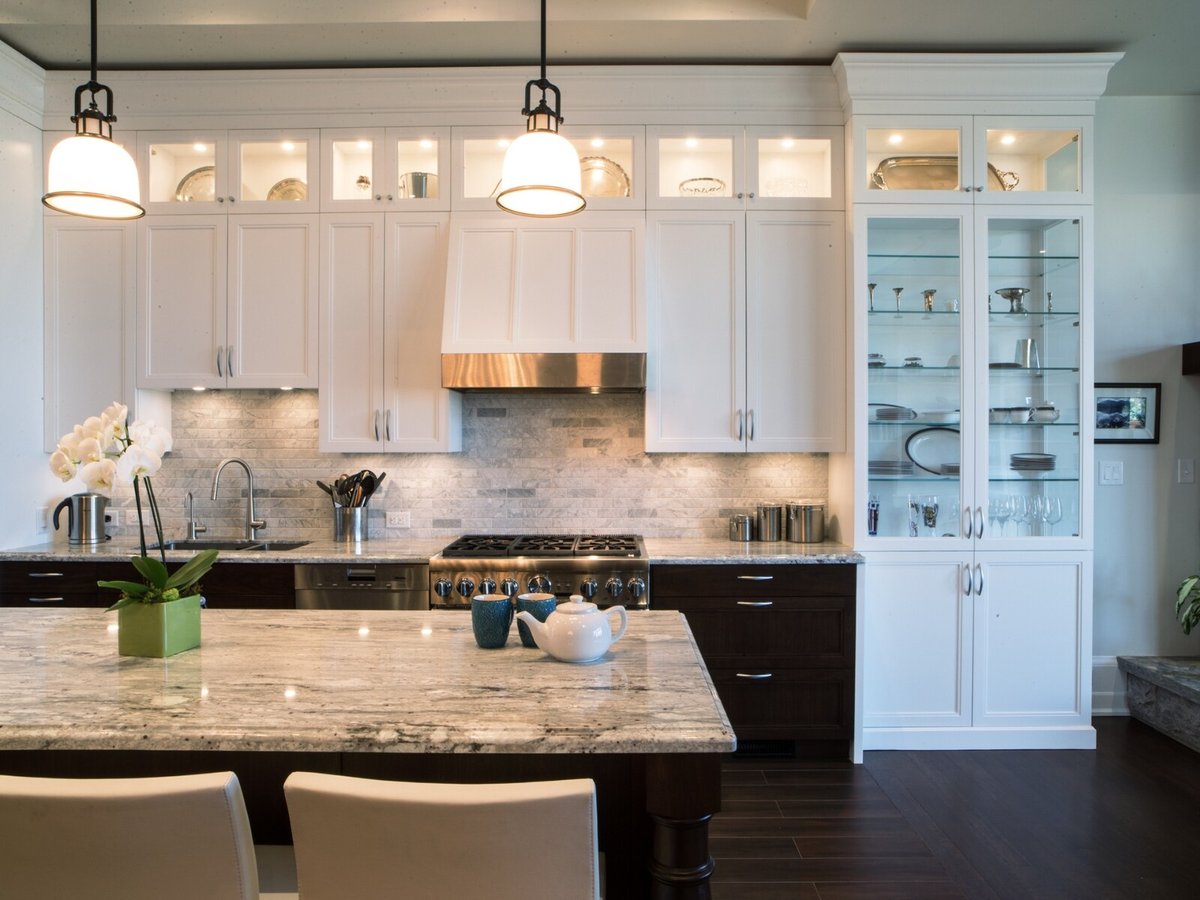 Stone backsplash in kitchen with range hood and kitchen island