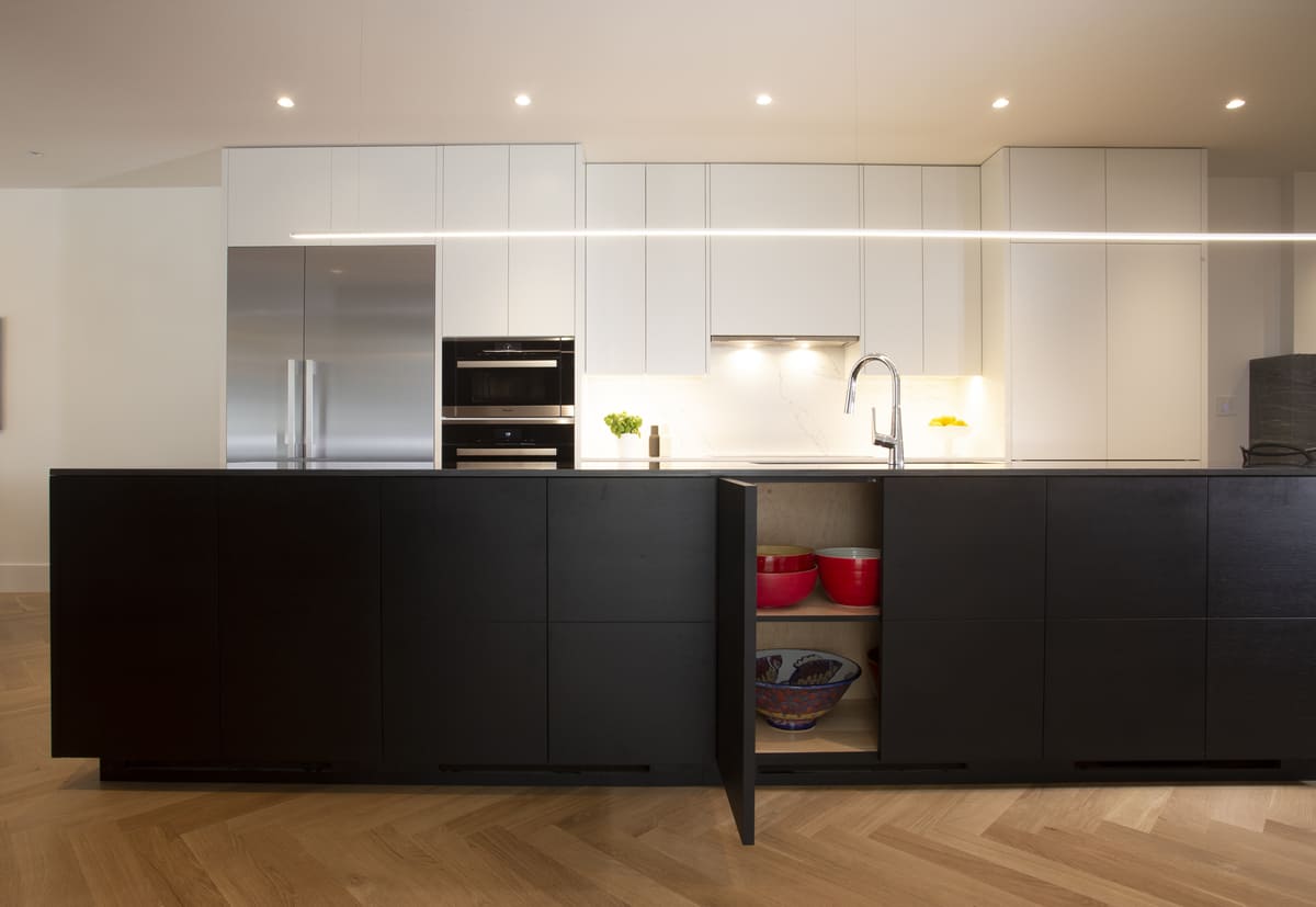 White flat panel cabinets and black kitchen island units in Toronto luxury home renovation