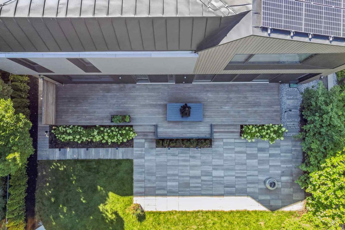 Aerial view of modern custom home with zinc cladding roof and solar panels