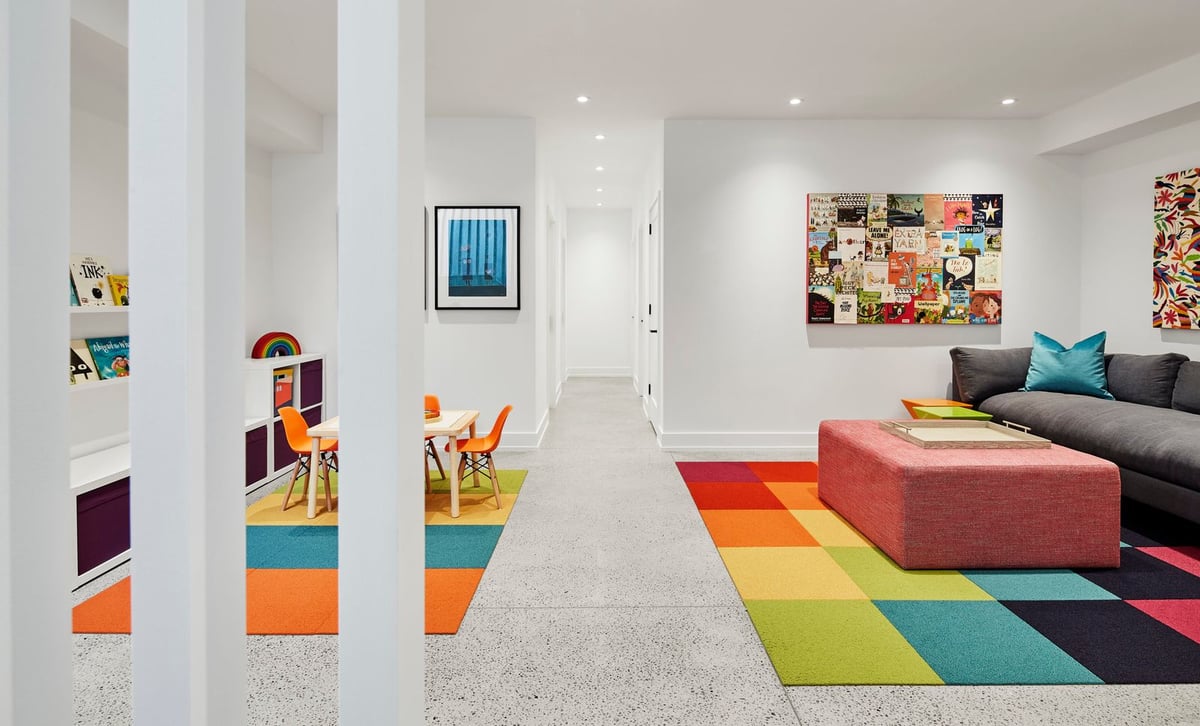 Contemporary basement with colourful mats and art on white walls