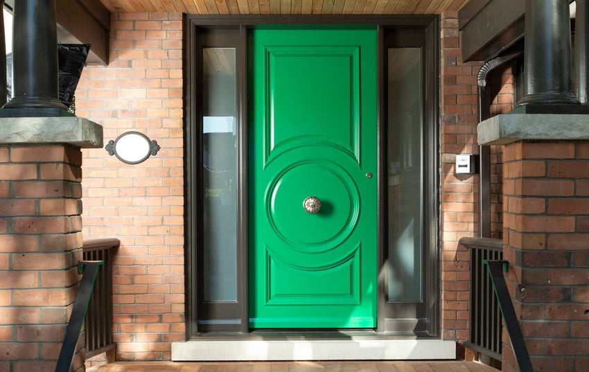 Exterior of bold green front door on custom brick home