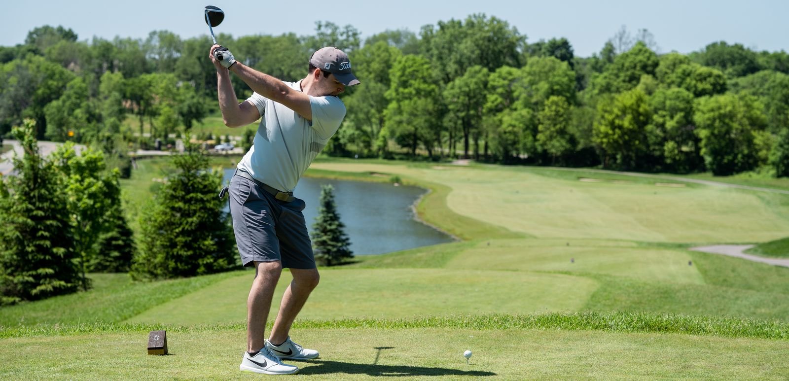 golfer mid swing on golf course near toronto