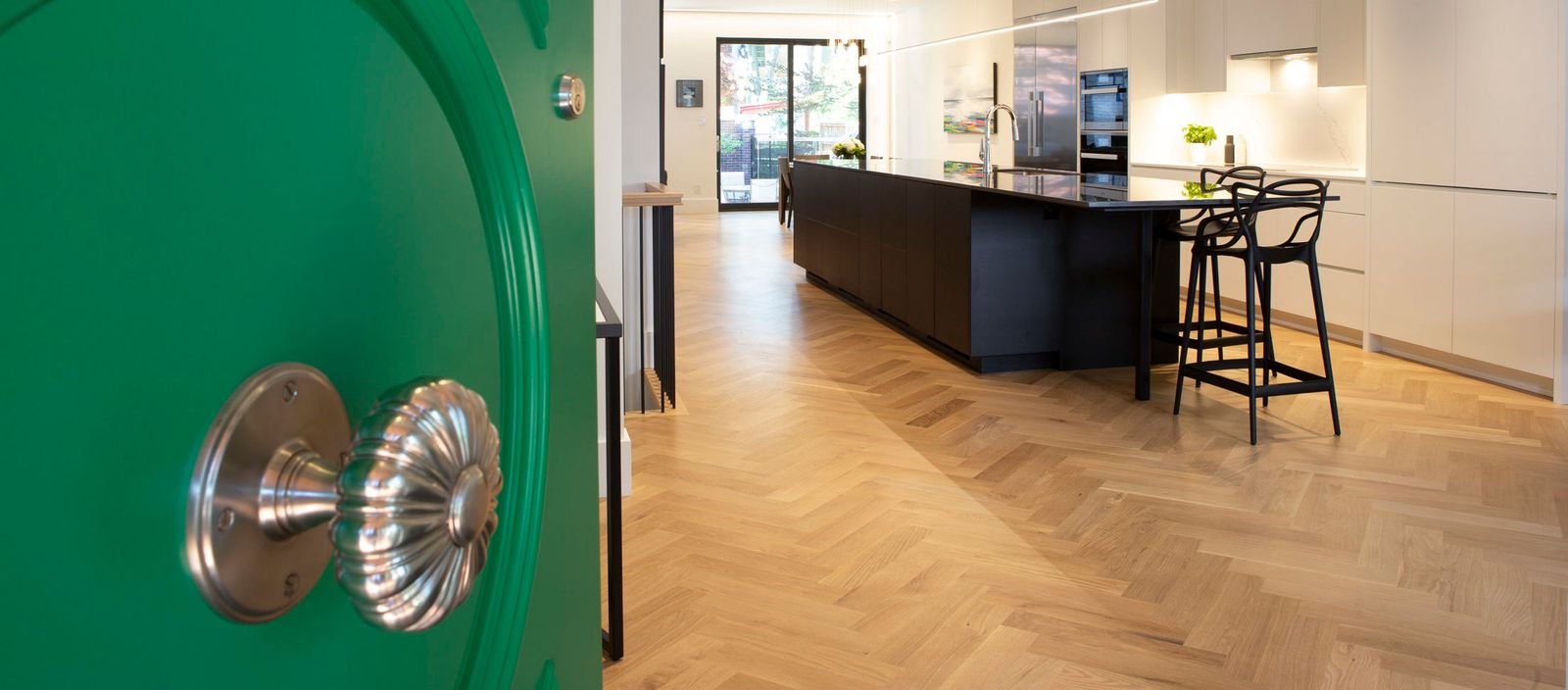 herringbone pattern floor in kitchen entryway with green door in playter estates toronto