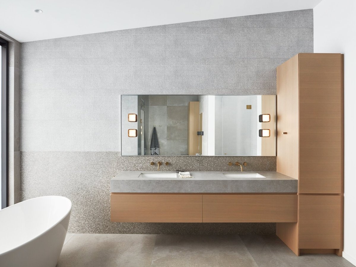 natural stone wall in bathroom with floating vanity and freestanding tub