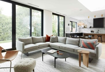 Open-concept first-floor kitchen and living area by floor-to-ceiling windows