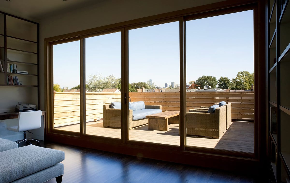 Secluded back deck of home with sliding glass doors