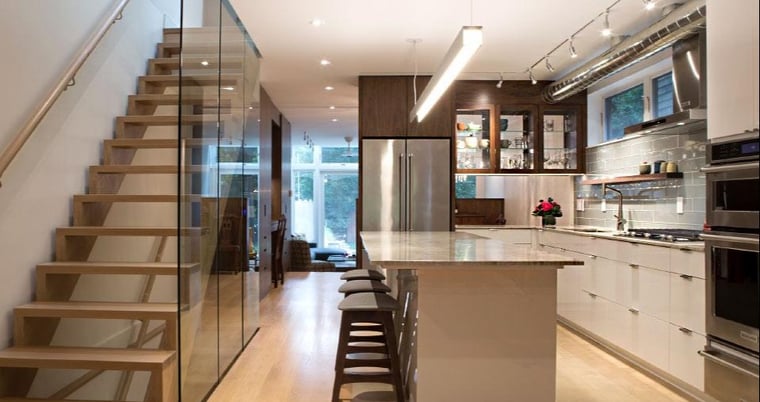 whole home renovation in old toronto of kitchen with island, floating stairs and glass wall
