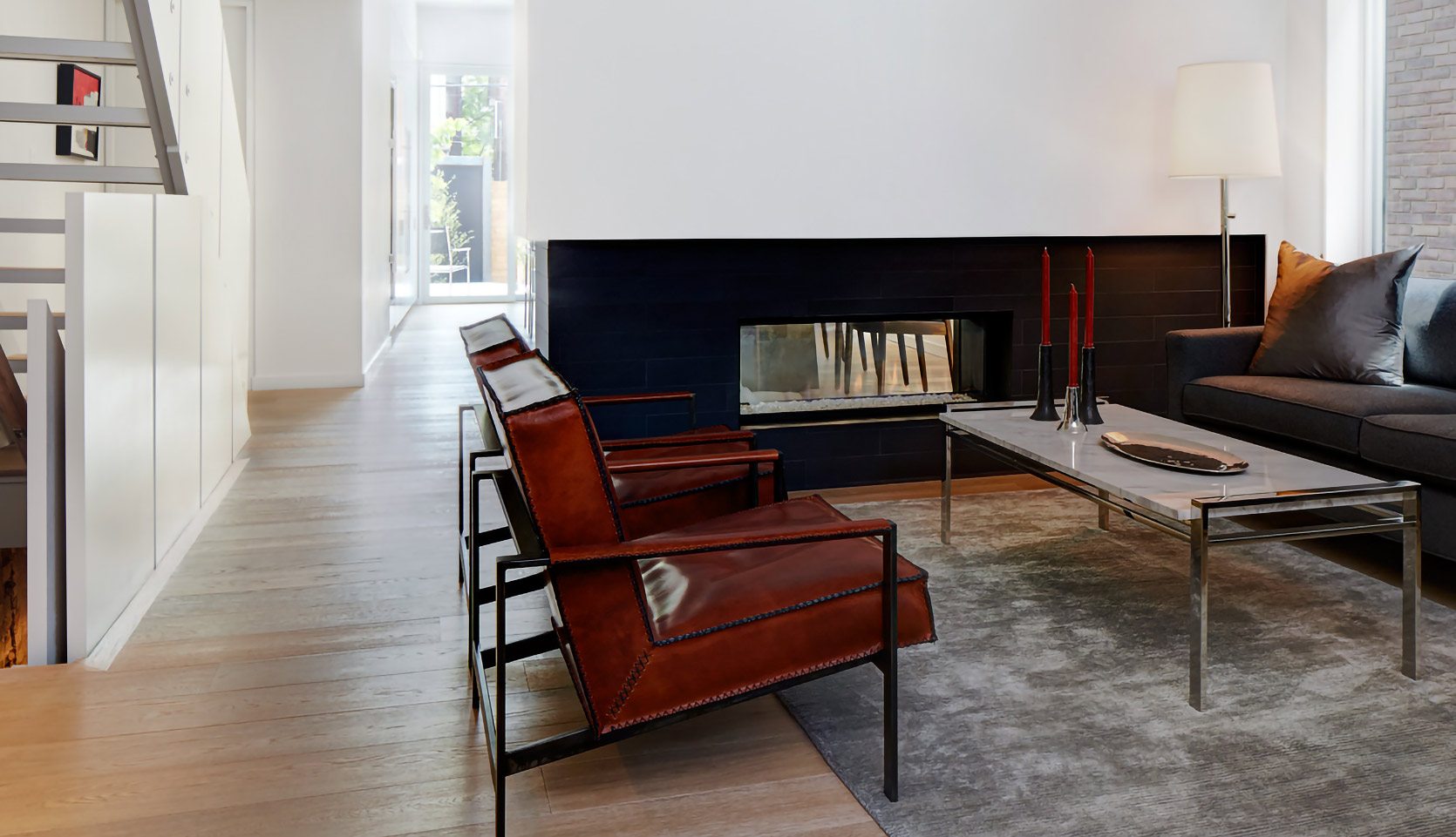 Contemporary living room with two red chairs and gas fireplace