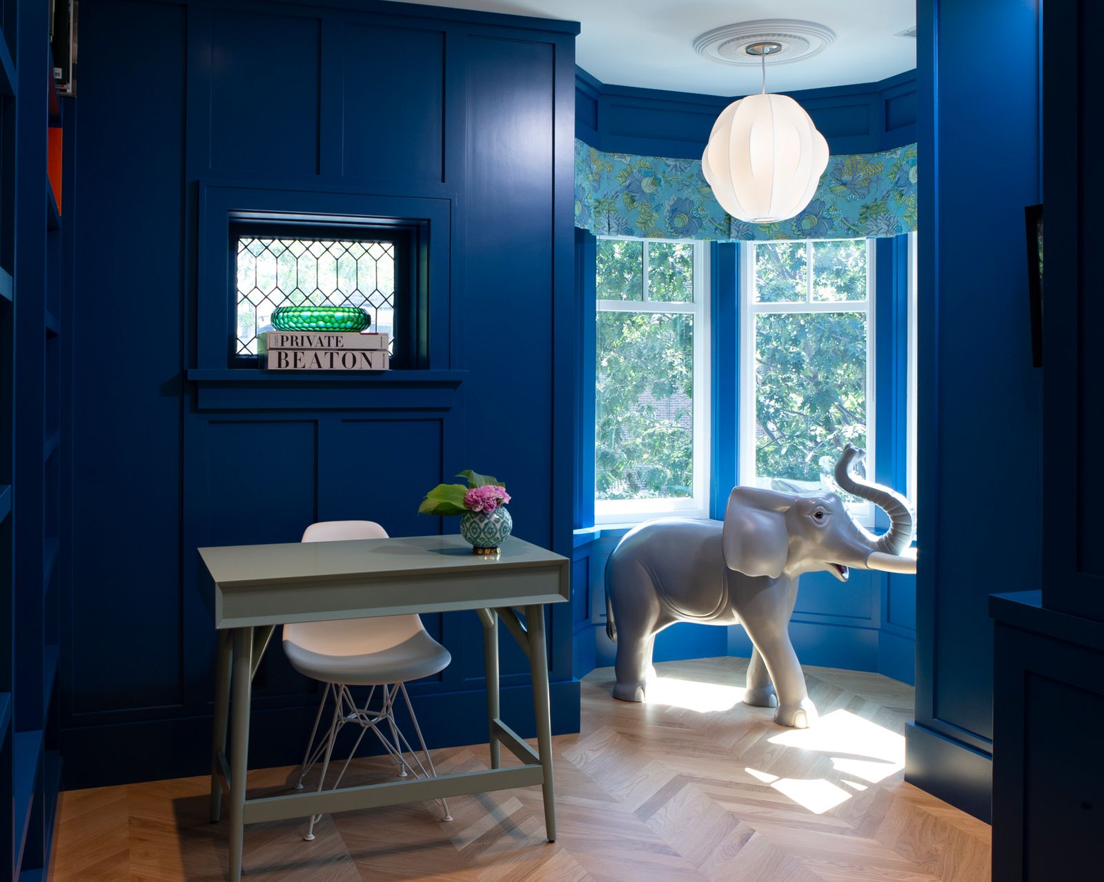 Blue office with glass patterned window above desk and chair