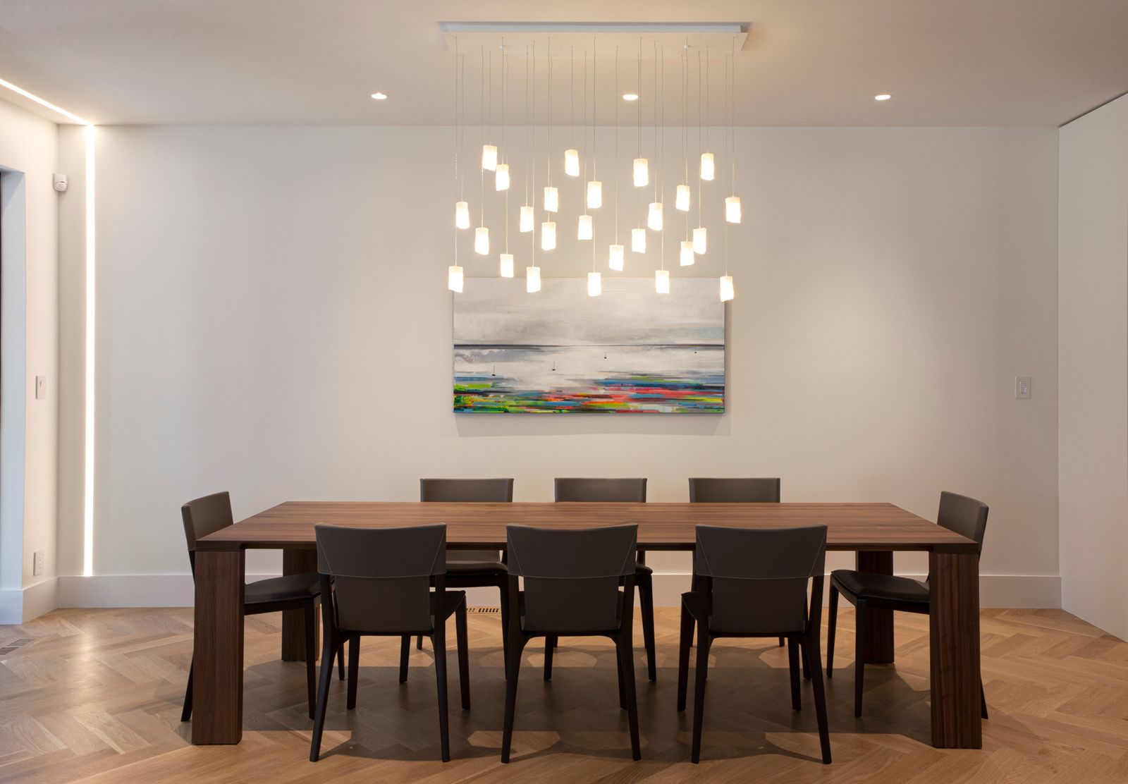 Minimal dining room with pendant lighting above large table