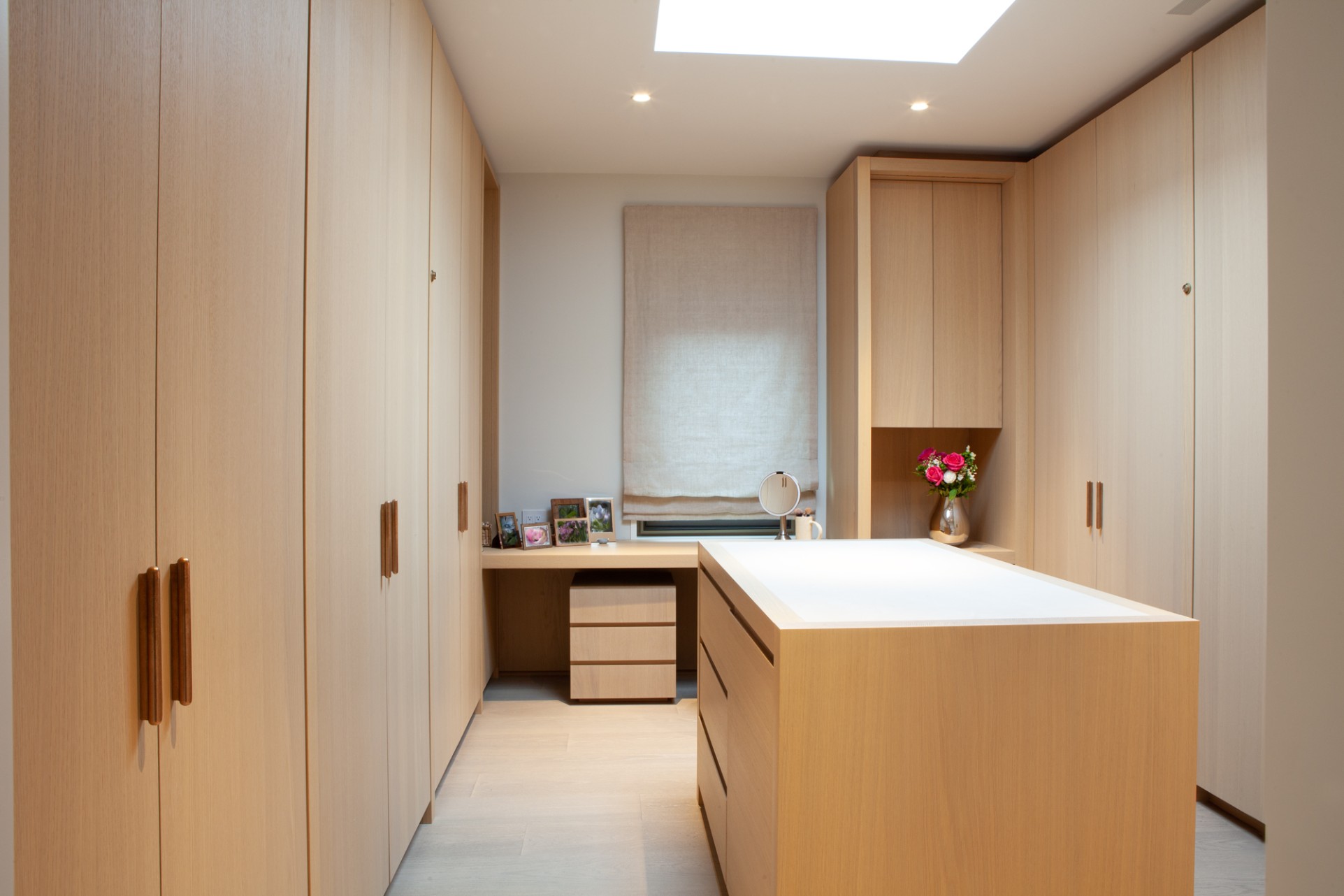 Island in walk-in closet beneath skylight in Toronto addition and renovation by SevernWoods