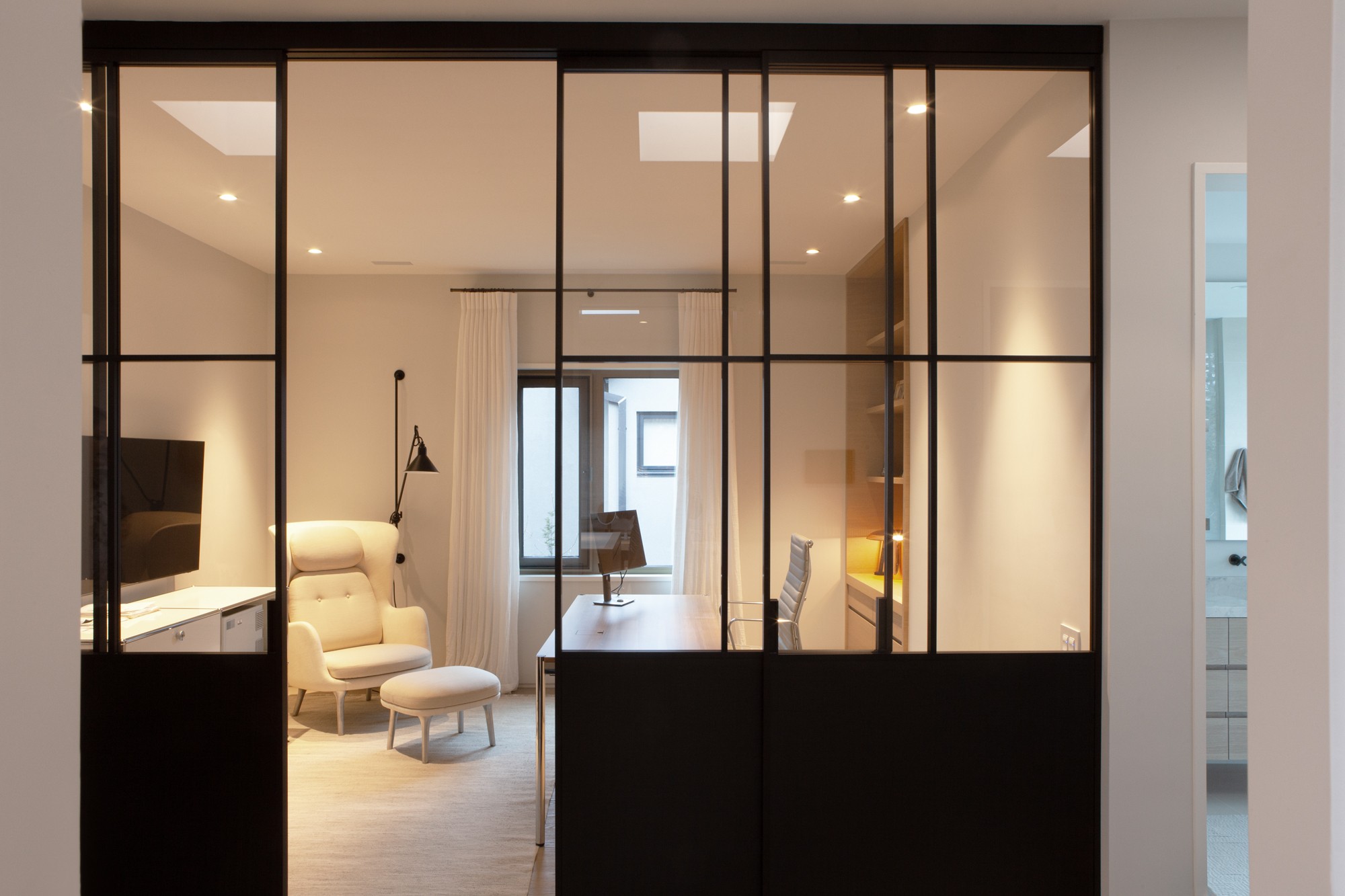 Luxury home office area with black sliding glass doors in Toronto renovation and addition by SevernWoods