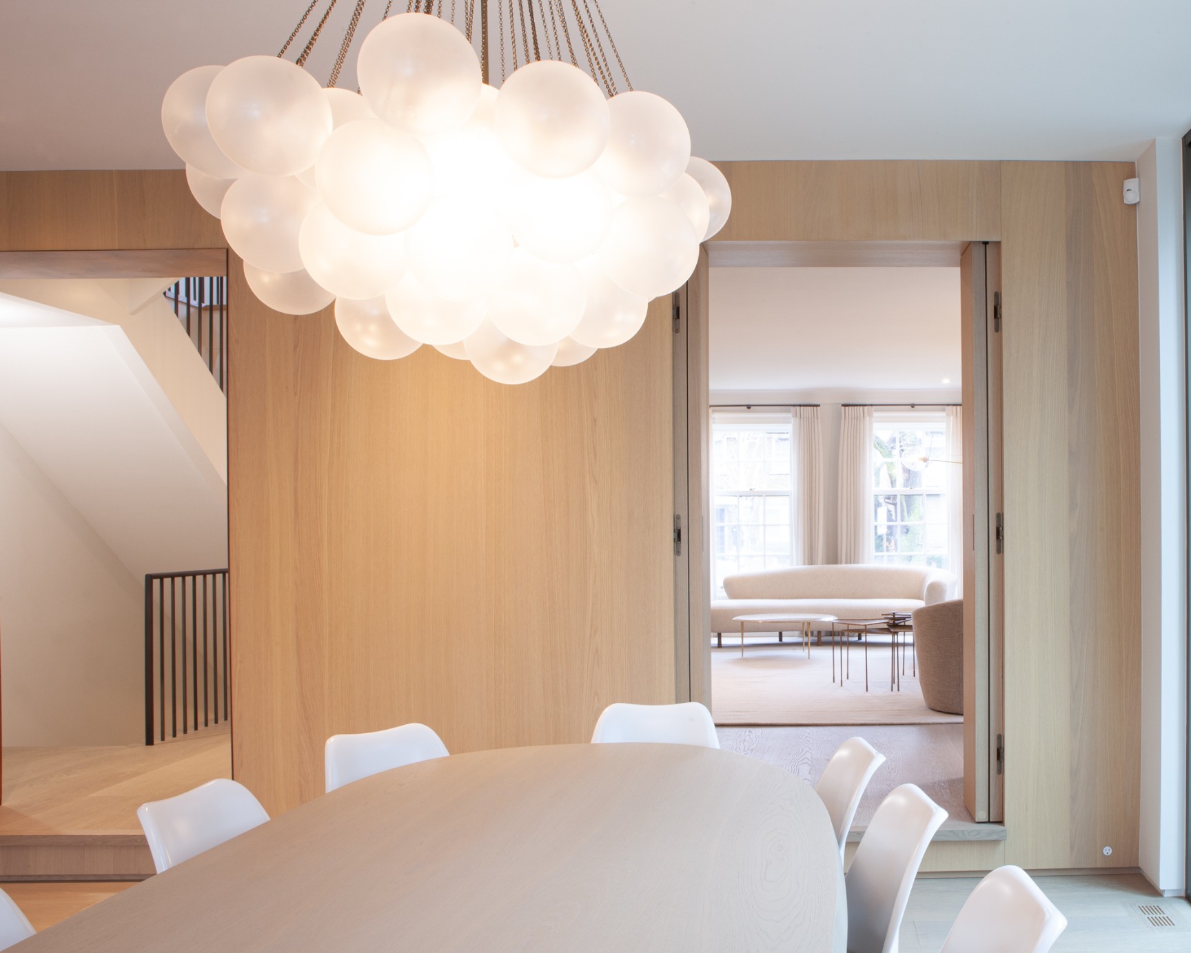 Modern light fixture above dining table in Toronto addition and renovation by SevernWoods