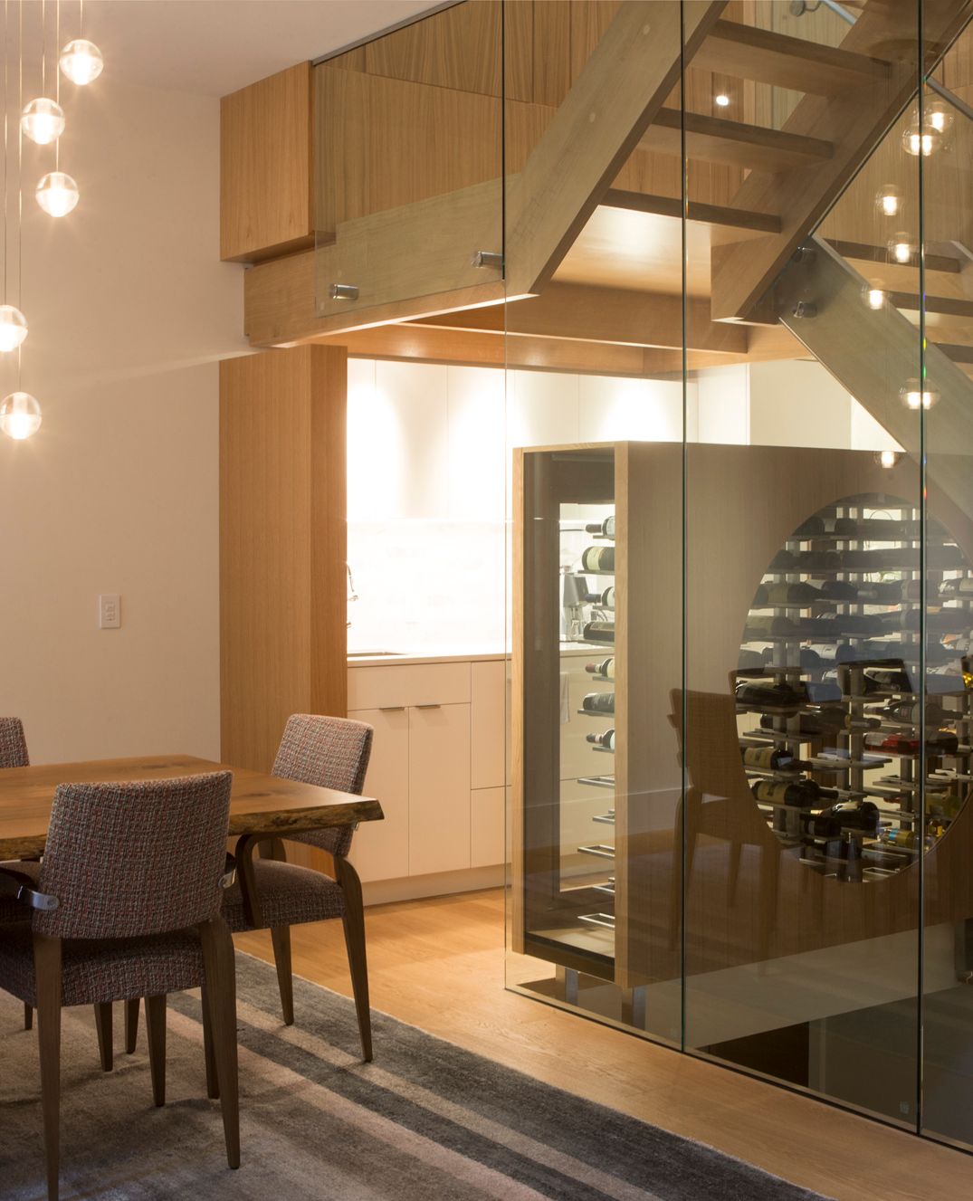 Dining room with floating glass staircase in custom luxury home