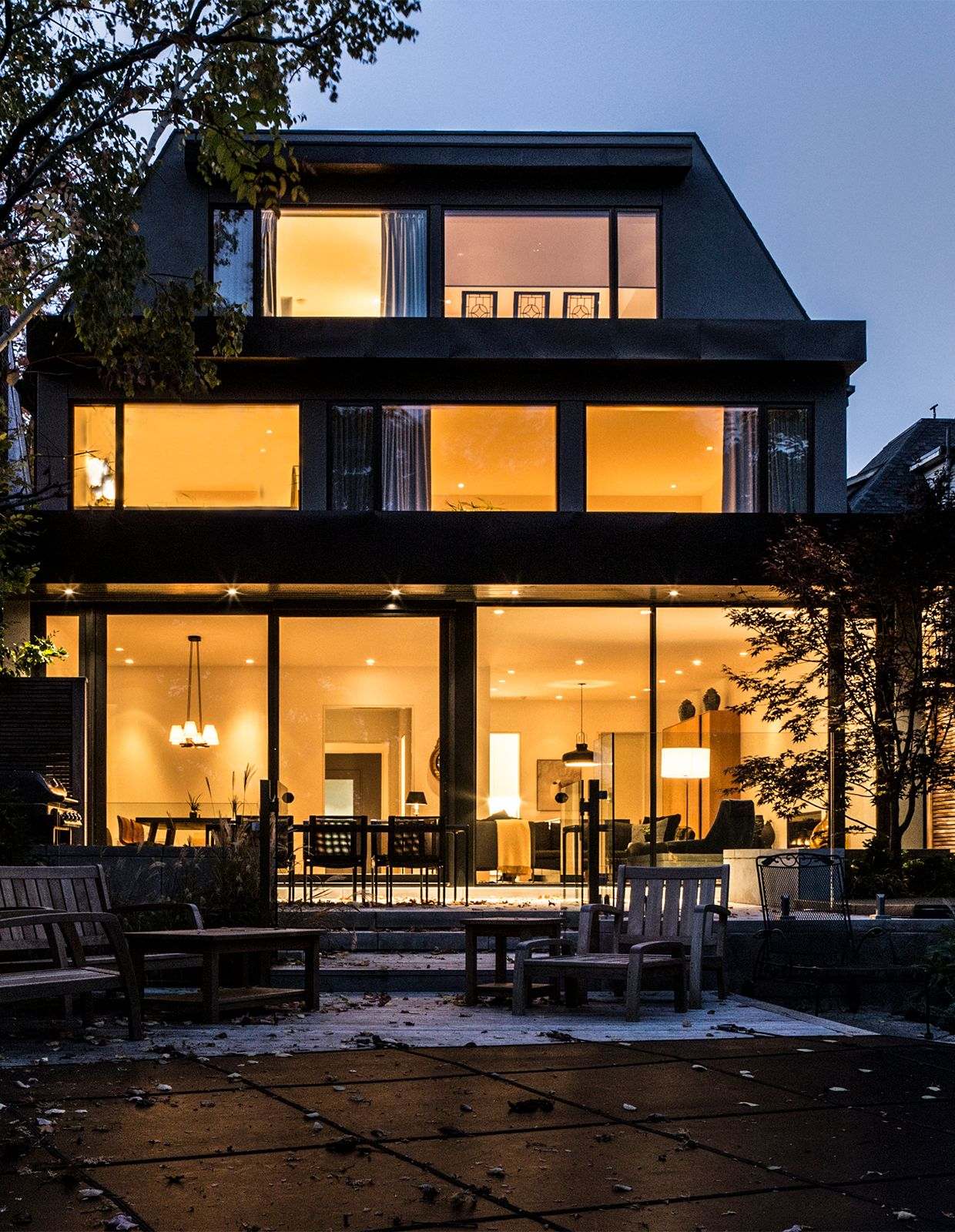 Modern contemporary exterior home at dusk with floor-to-ceiling windows