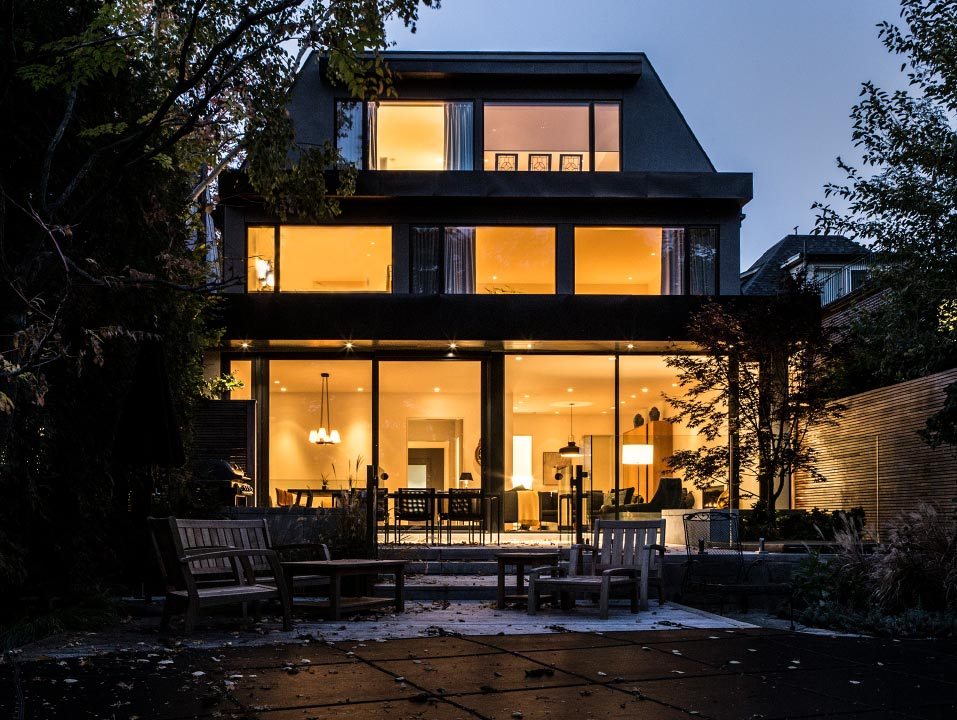 Modern contemporary exterior home at dusk with floor-to-ceiling windows