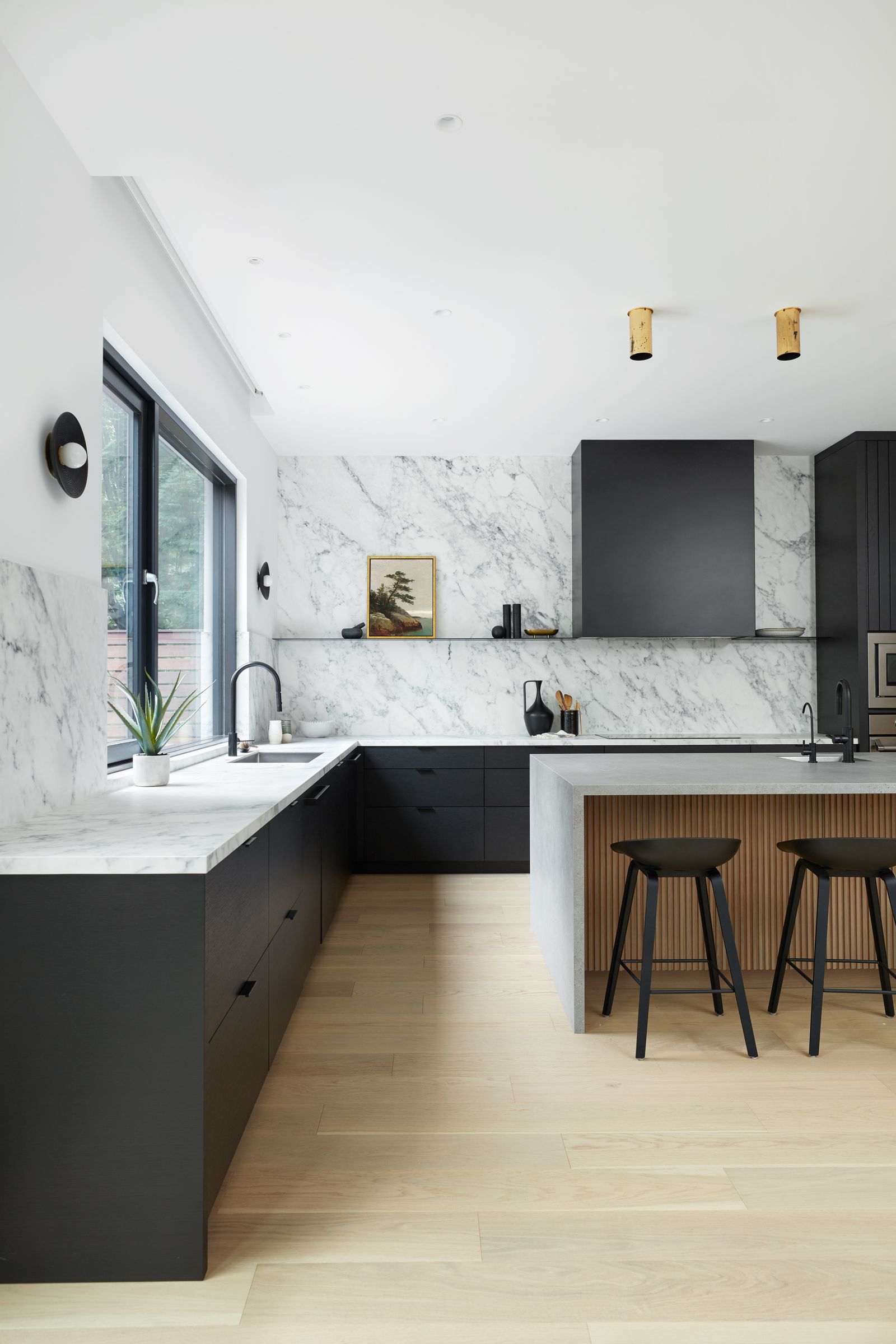 Modern kitchen renovation with black flat panel cabinets and slab countertops & backsplash